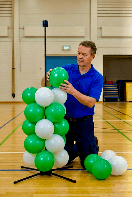 Schulmitarbeiter baut PilaMania Ballondekoration selbst auf für Abschlussfeier